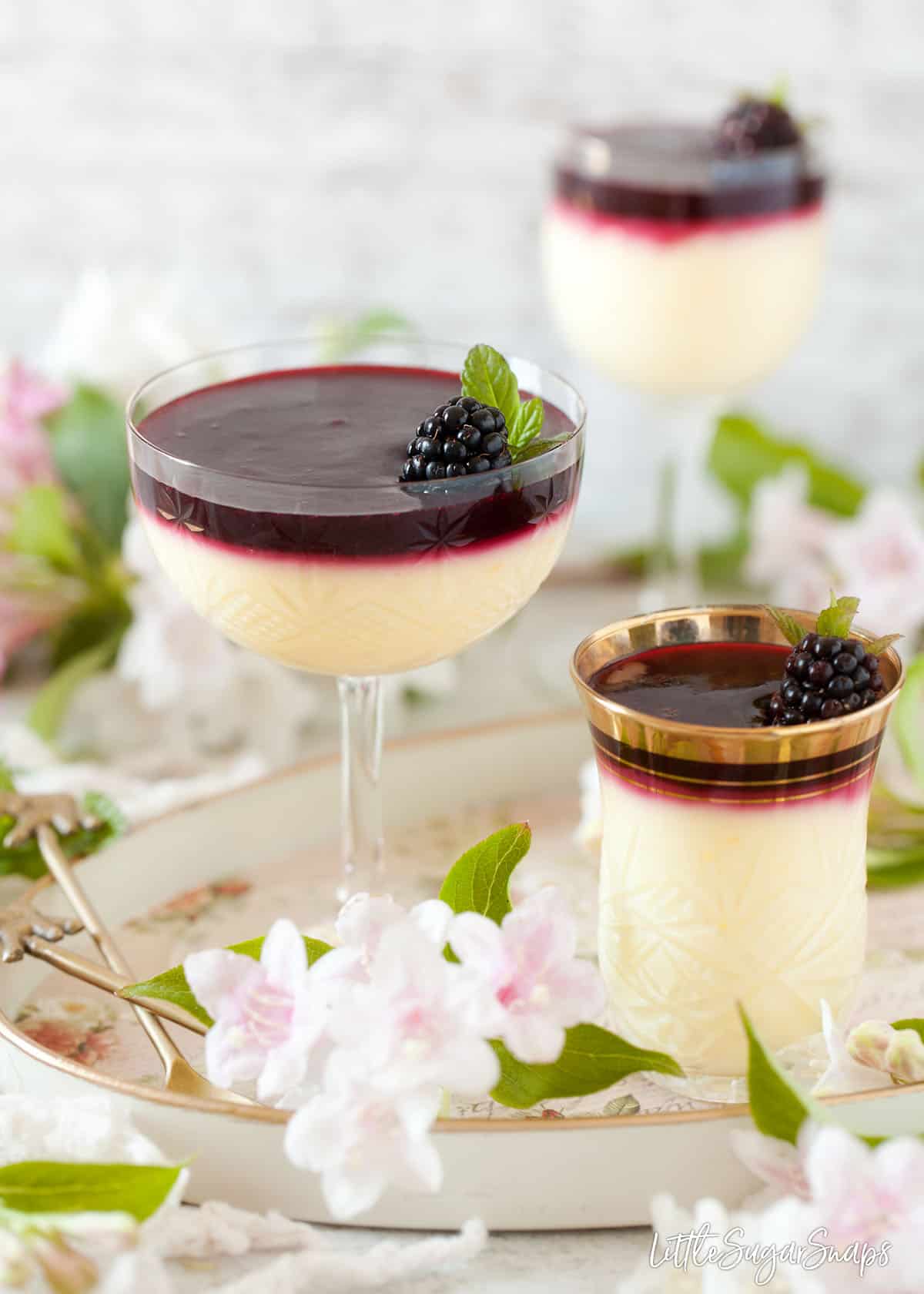 Vintage glasses filled with lemon posset and blackberry sauce