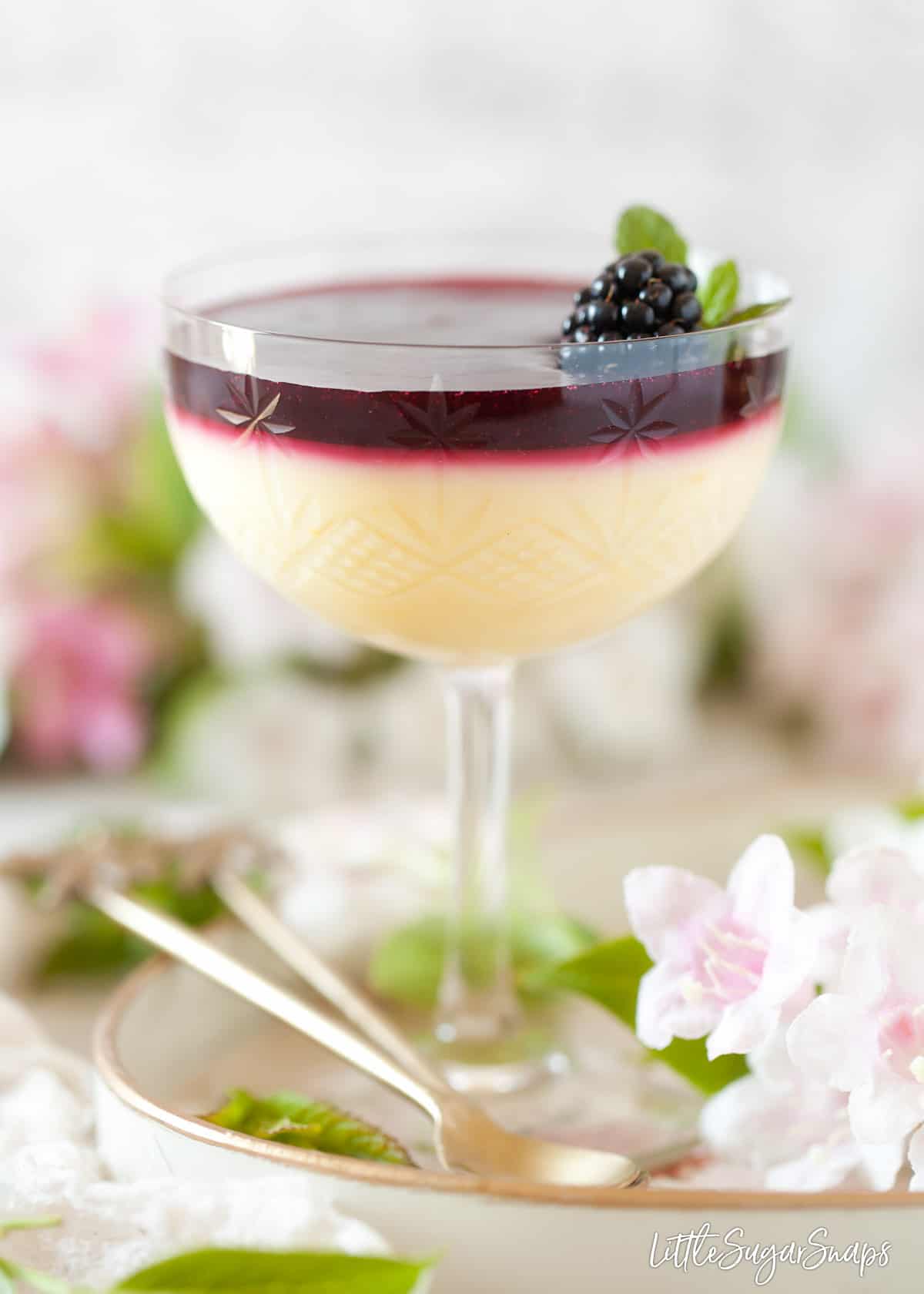 Lemon posset topped with blackberry sauce in a vintage glass