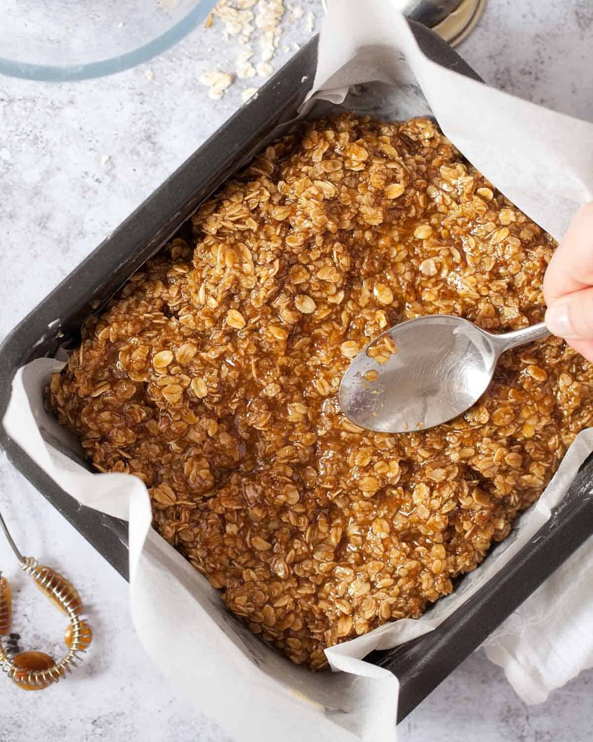 Spreading Biscoff flapjack mixture into a pan ready for baking