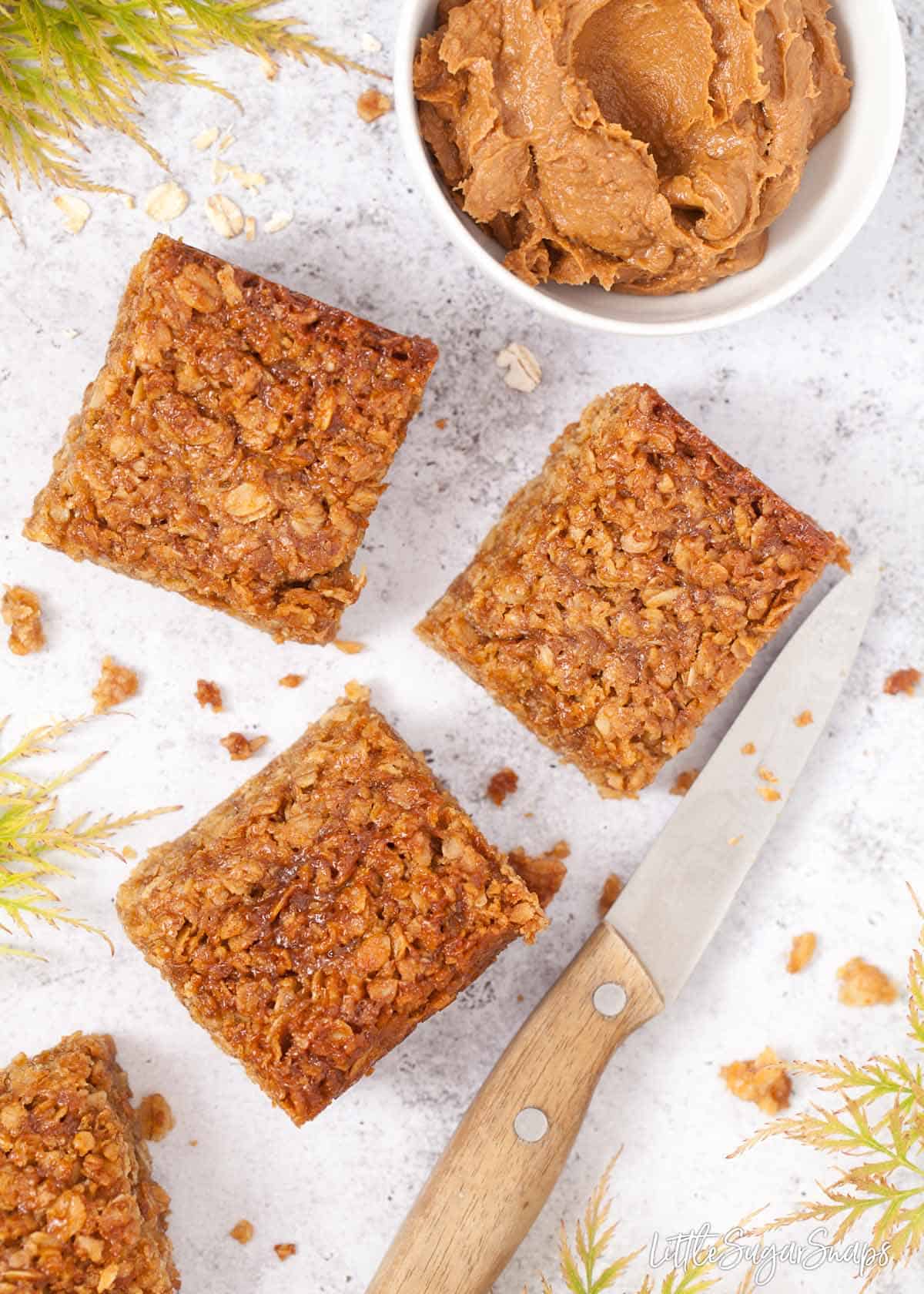 Flapjack pieces and ingredients on a worktop