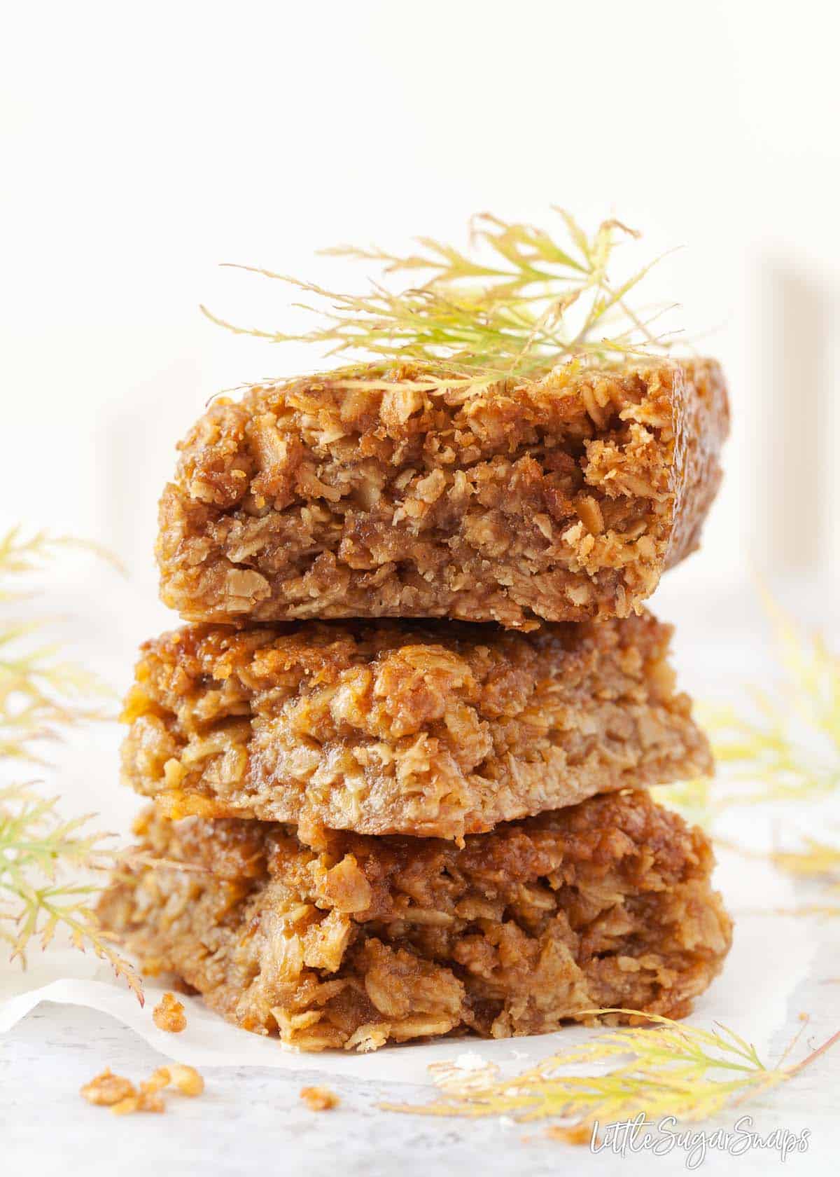 Three squares of Biscoff flavoured flapjack stacked on top of each other