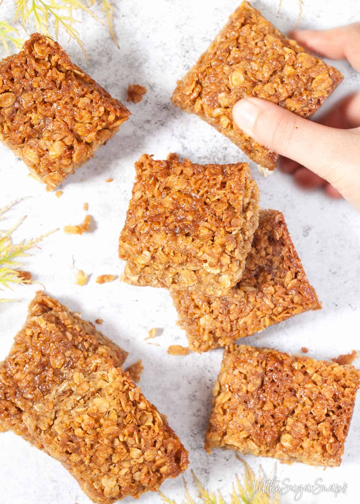 Child taking a piece of flapjack from a worktop