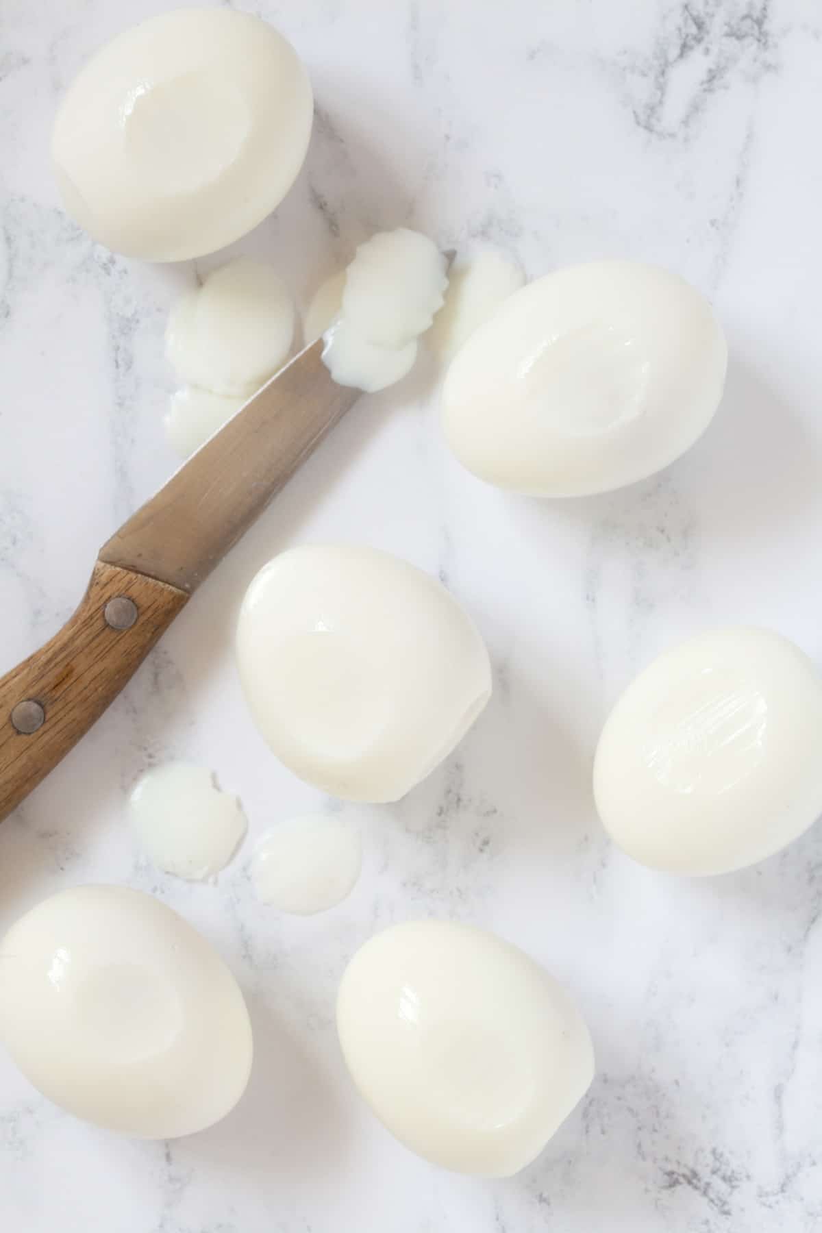 Slicing hard boiled eggs in preparation for making devilled eggs