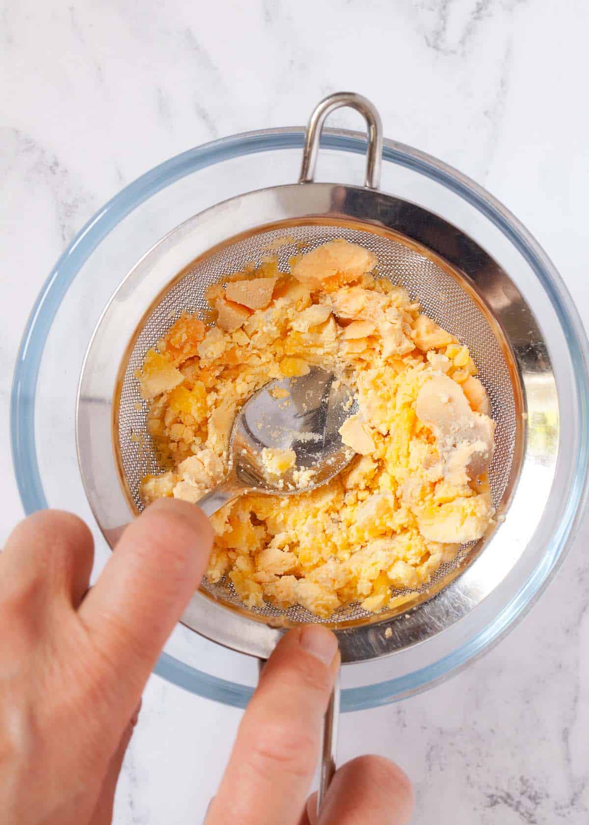 Pushing egg yolk through a fine-meshed sieve