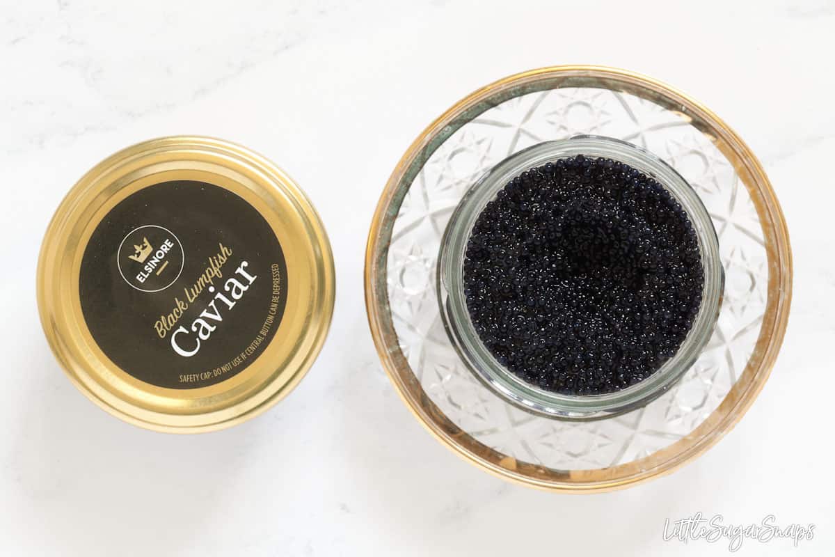 Two pots of black lumpfish caviar. One is open, one is closed.