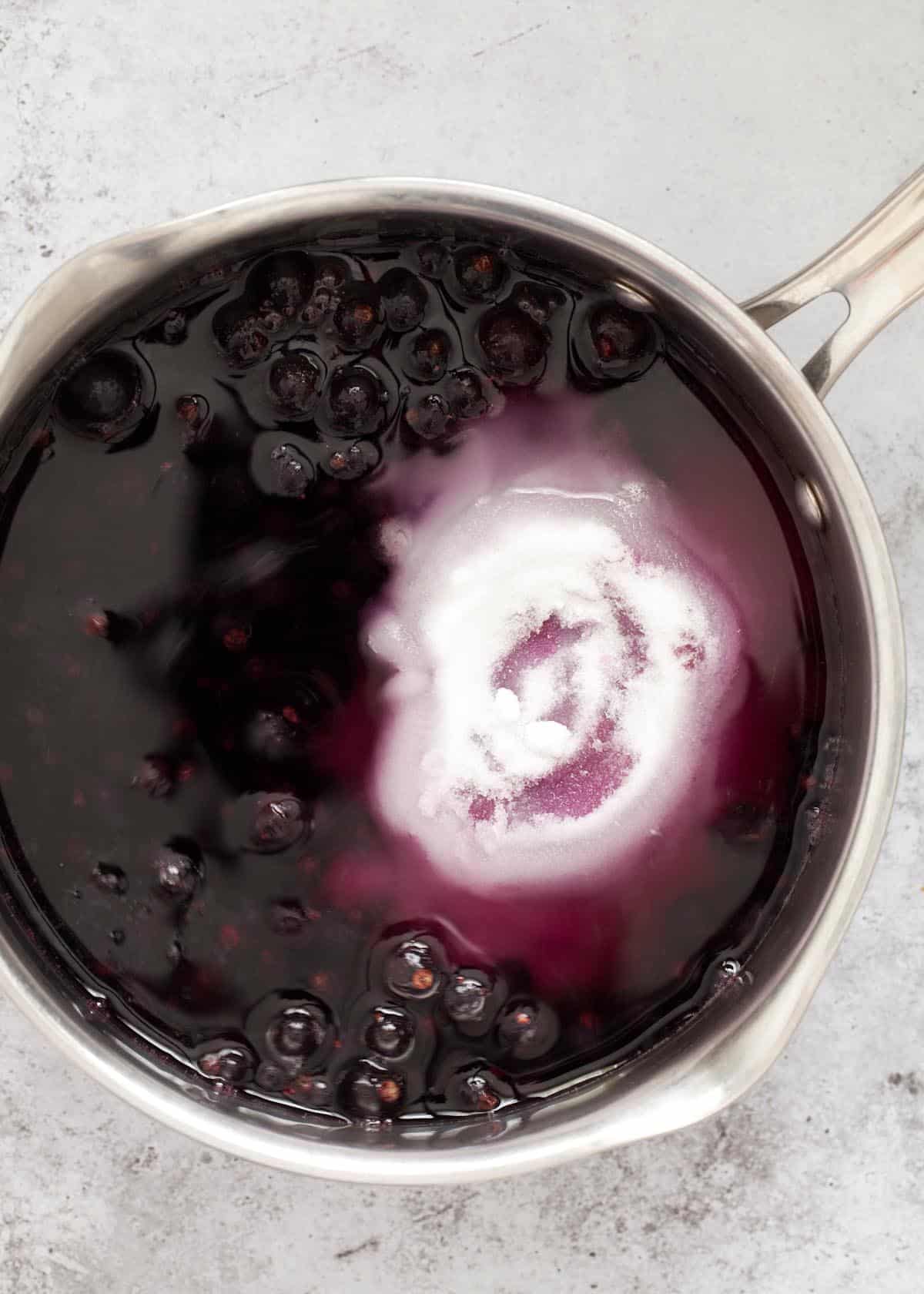 frozen fruit, sugar and water in a saucepan