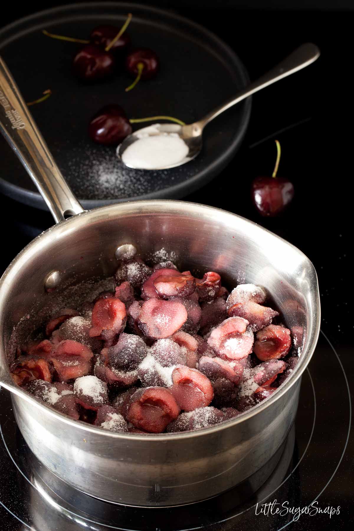 Cherries and sugar in a pan prior to cooking into jam