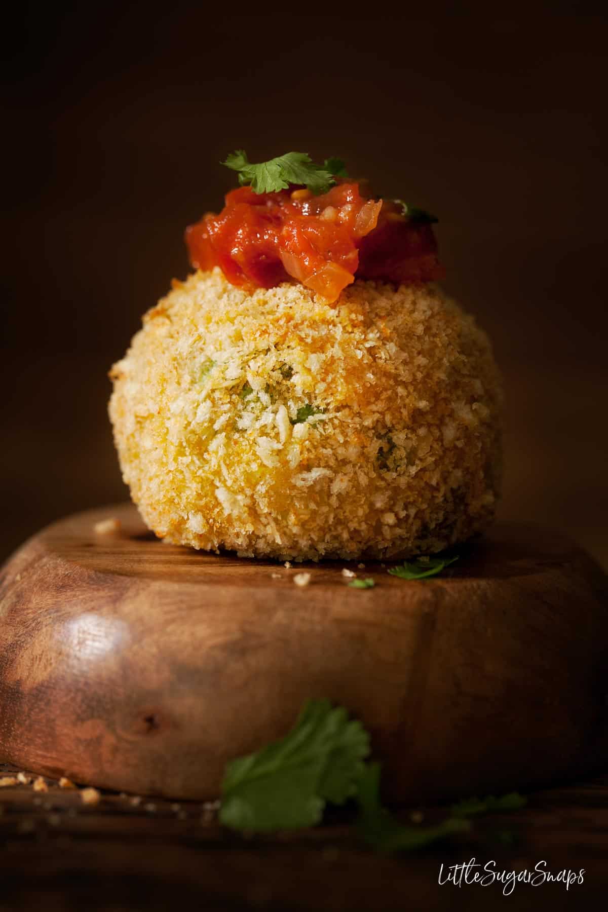 A smoked haddock fish cake with a spoonful of spiced tomato sauce