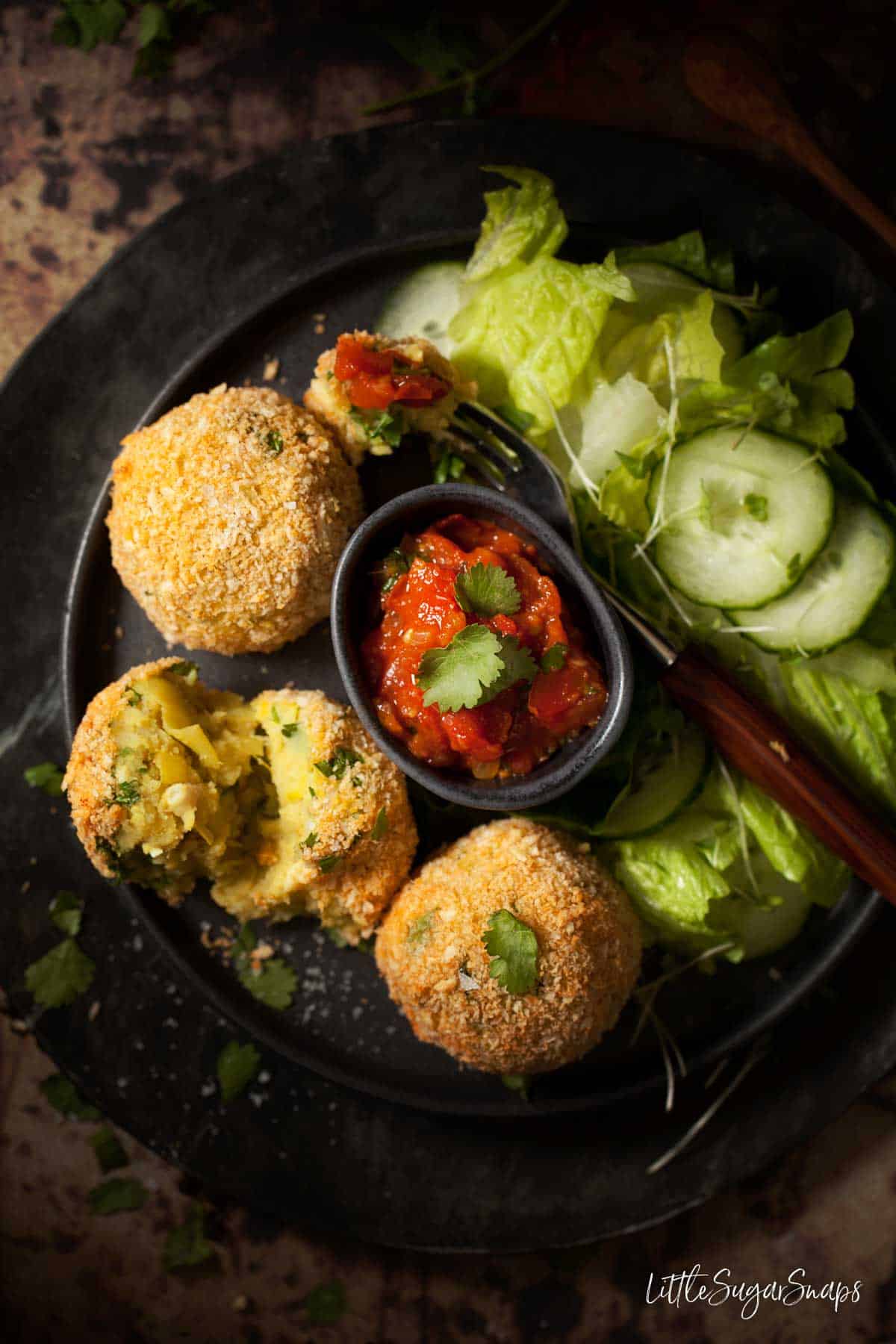 Three smoked haddock fish cakes served with spicy tomato sauce and a green salad