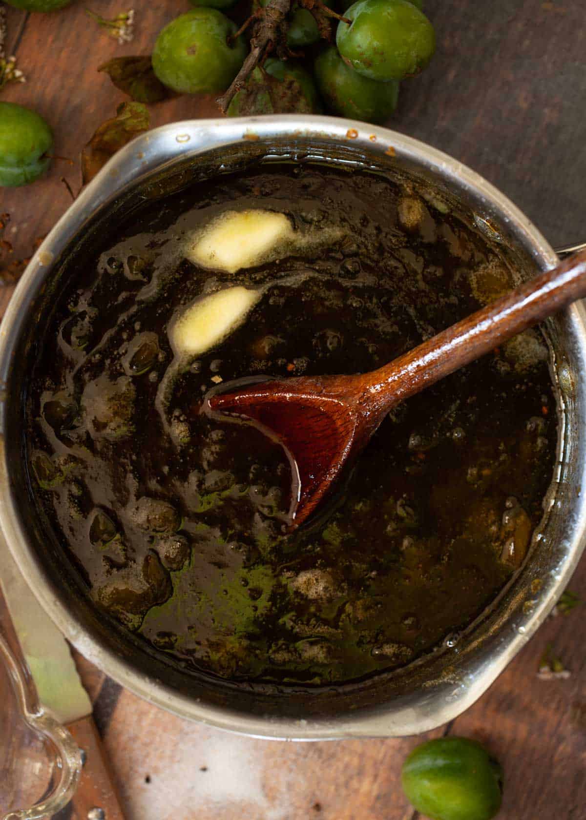 Process image - stirring a knob of butter into a saucepan of cooked fruit conserve