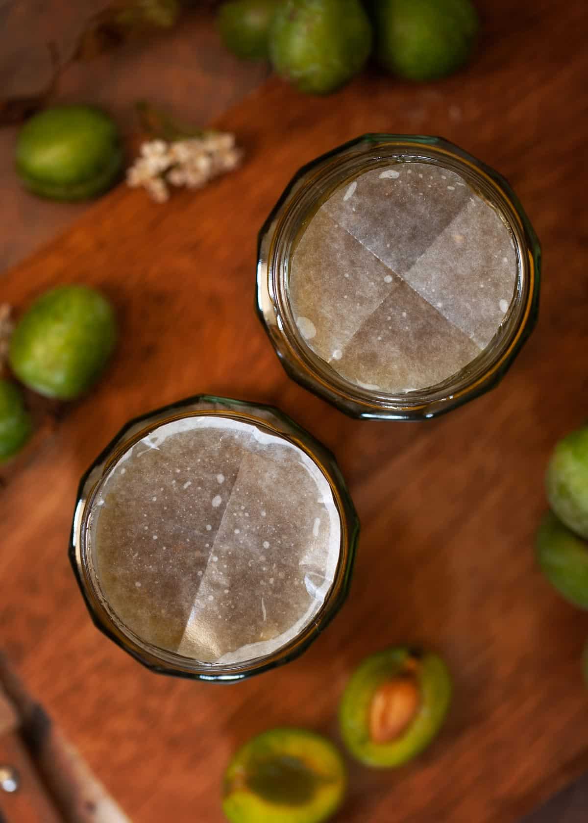 Two jars of fruit conserve freshly filled and covered with wax discs