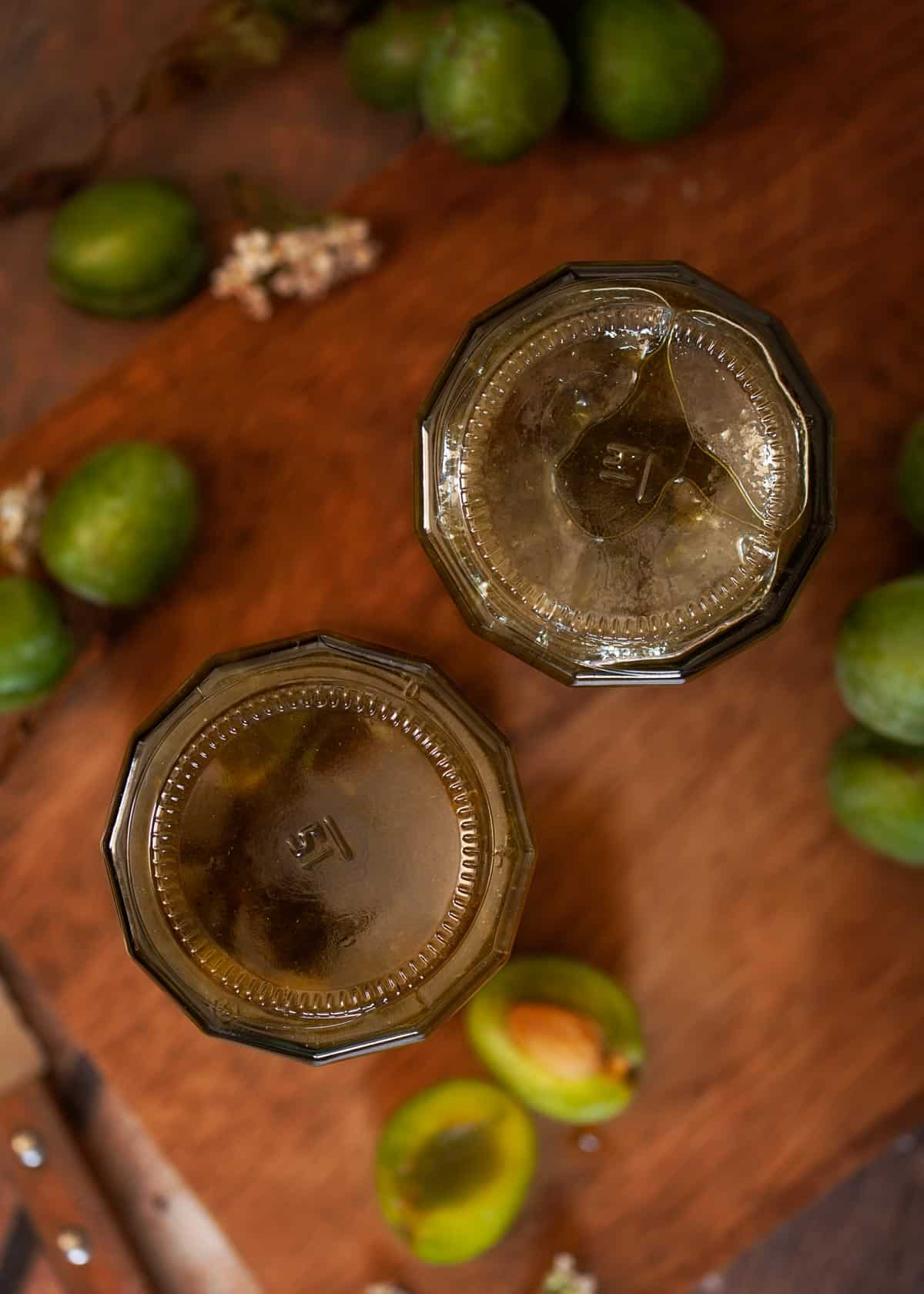 Two upturned jars of fruit conserve on a wooden board.