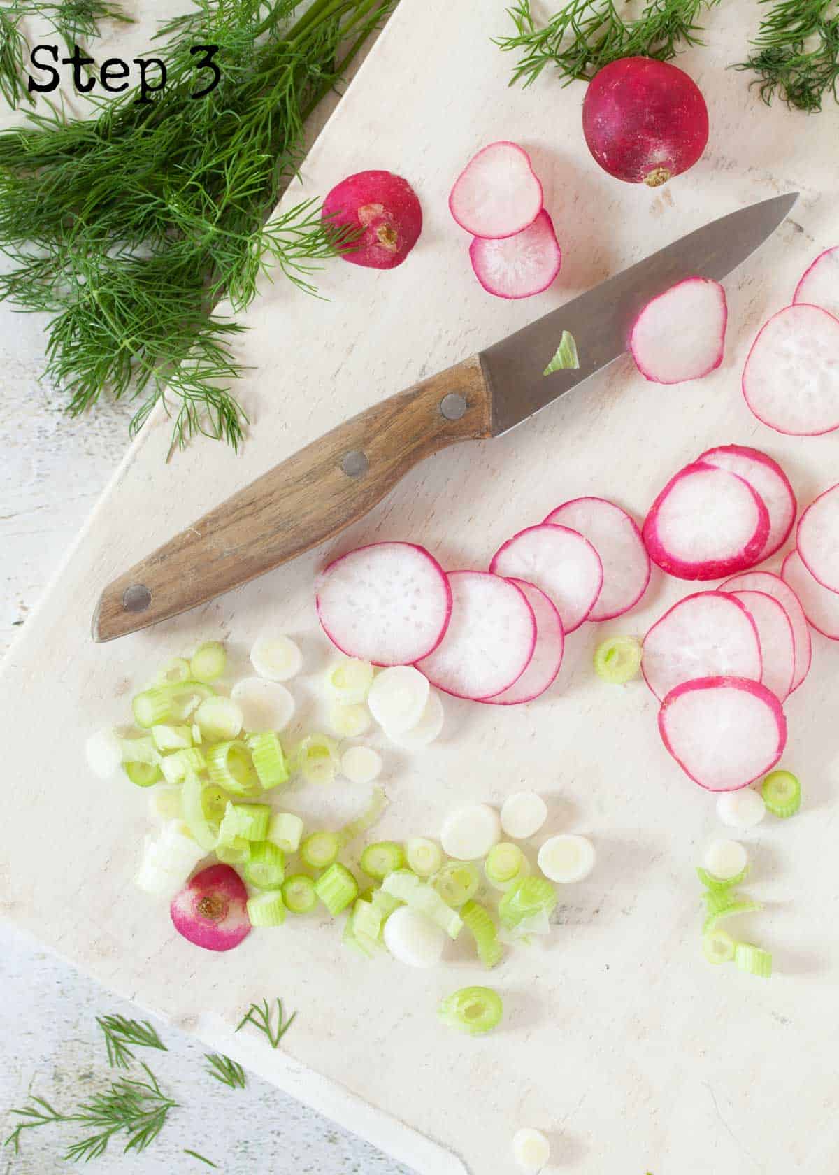 Process image - sliced radish and salad onion on a wooden board