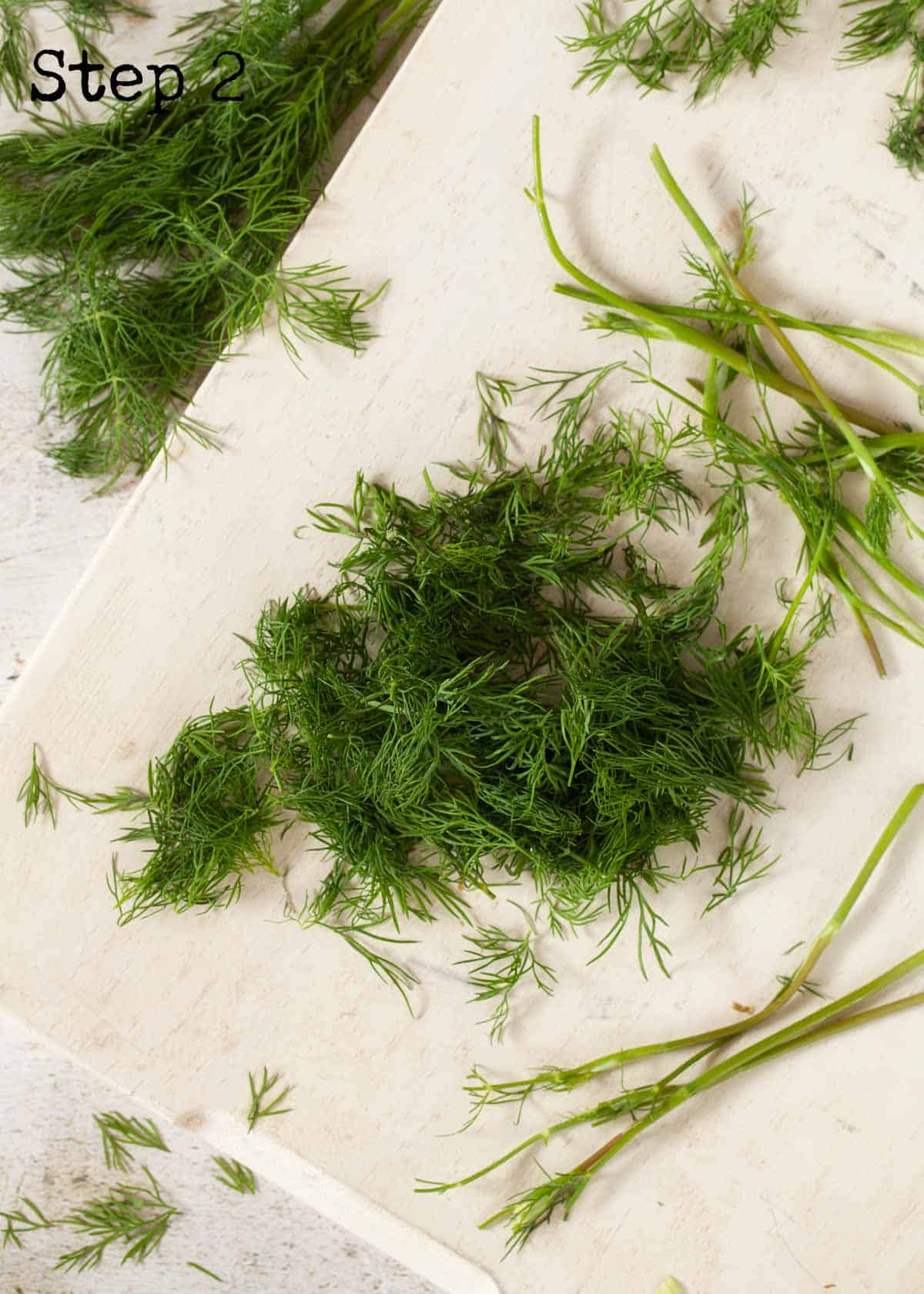 Process image - fresh dill removed from stems on a chopping board