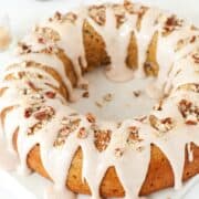 Close-up of a spiced bundt cake with cinnamon frosting, nuts and coconut.