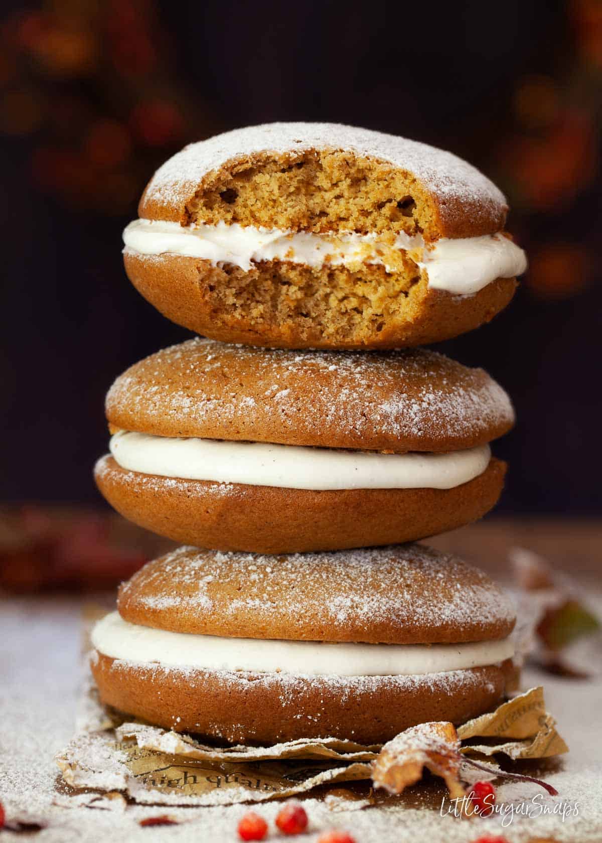 A stack of Maine whoopie pies flavoured with pumpkin. One has been bitten into.