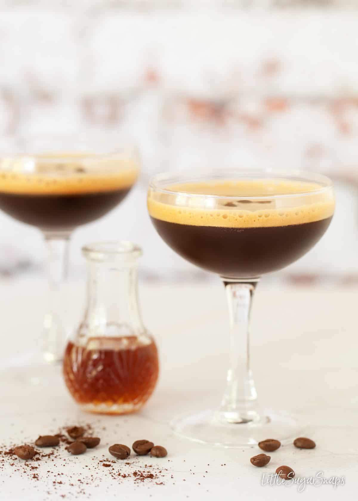 Glasses of caffè shakerato with a bottle of demerara sugar syrup