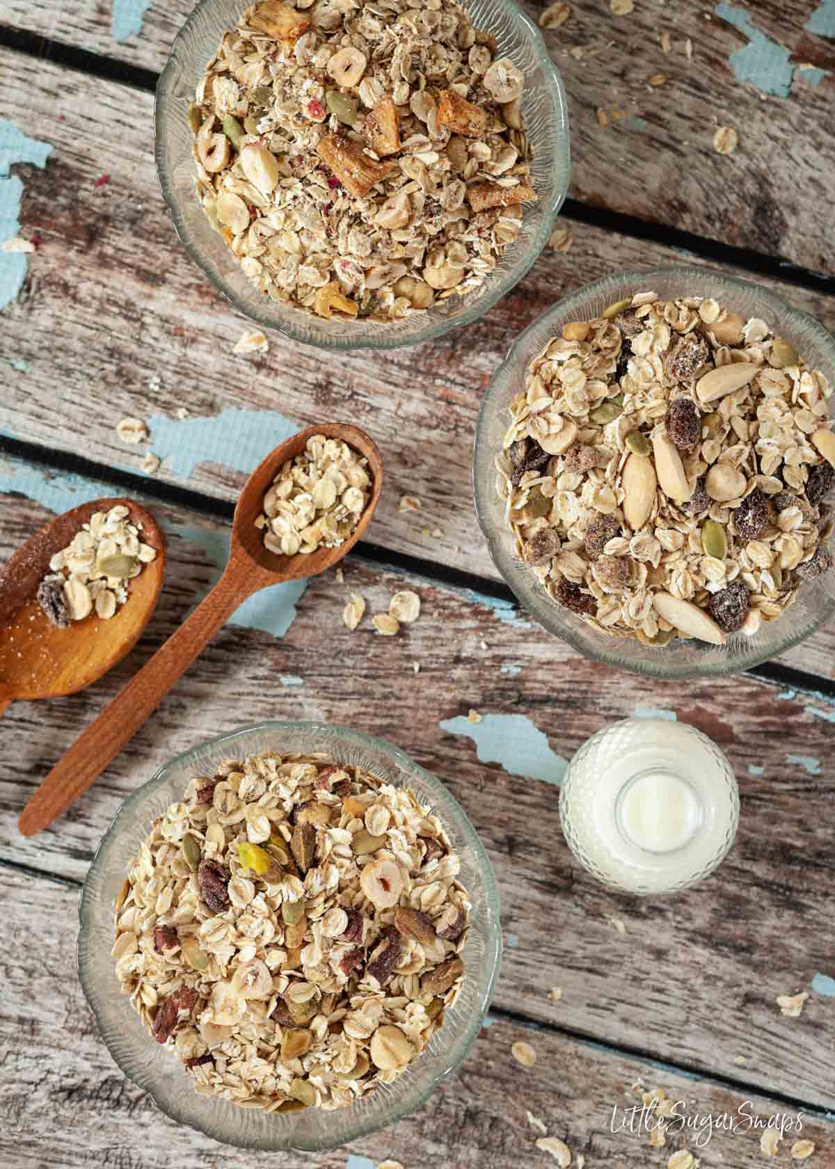 Three bowls of toasted cereal with a small bottle of milk