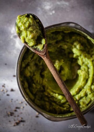 freshly cooked mushy peas on a spoon