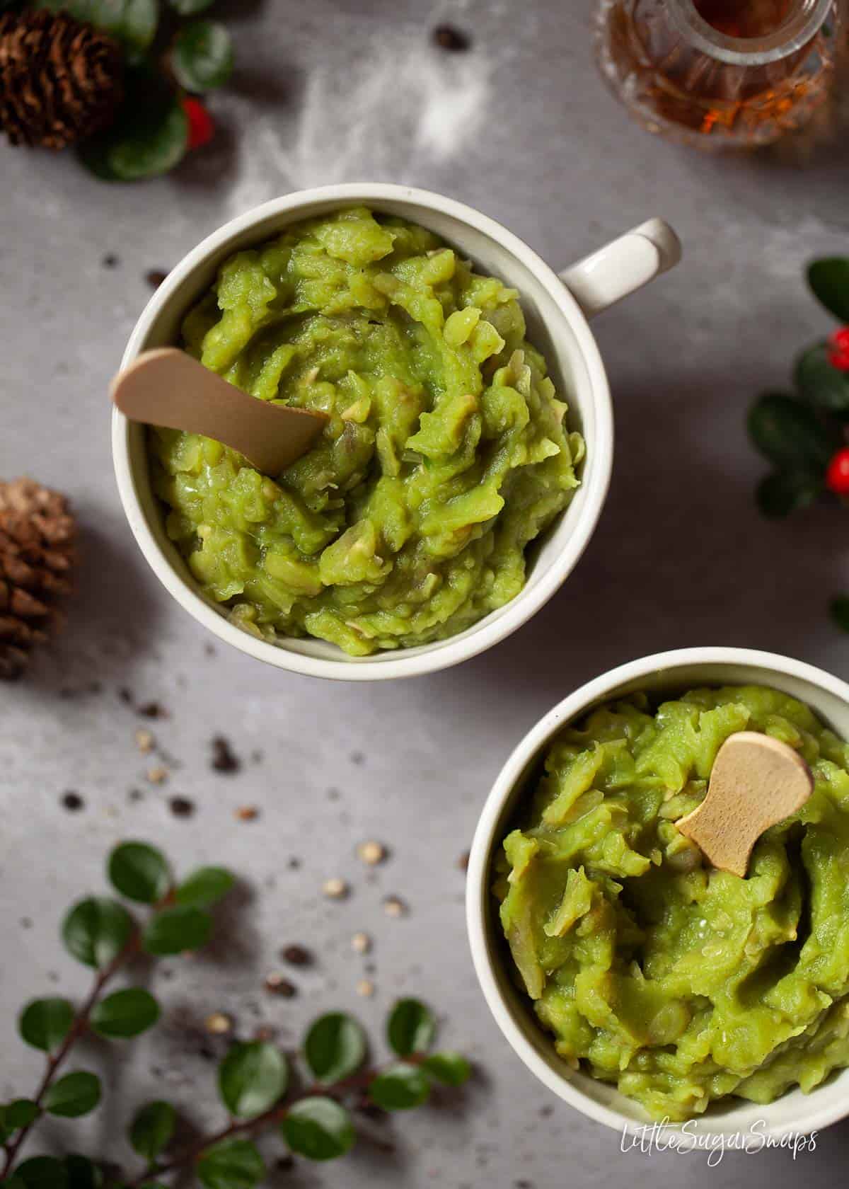 Homemade Mushy peas in mugs with wooden spoons