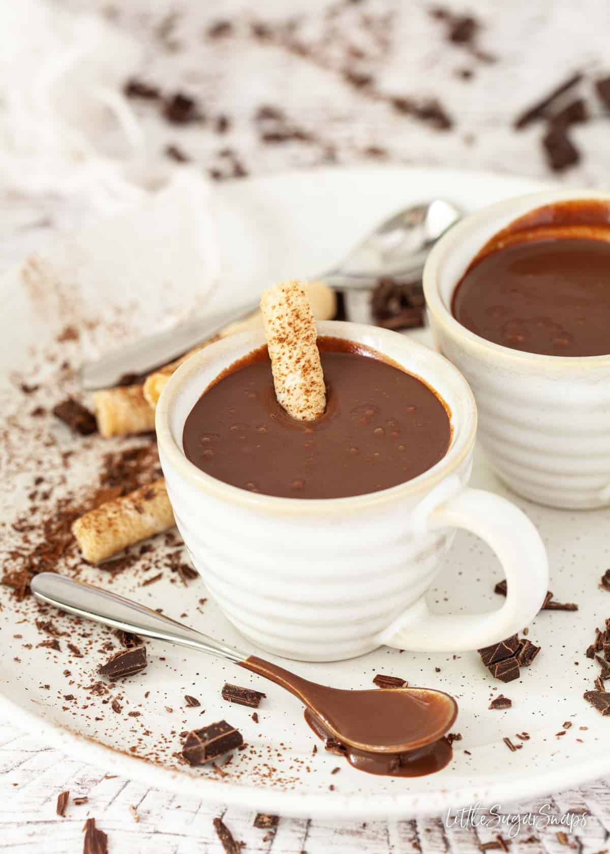 Two cups of Italian hot chocolate with wafers for dipping into the drink.