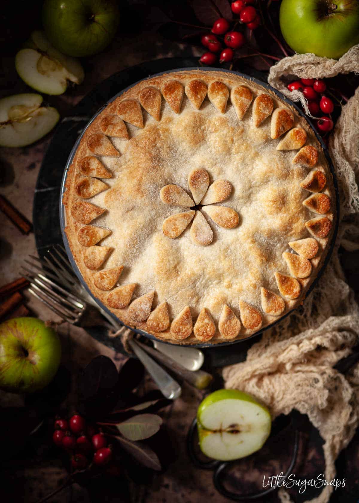 An uncut vegan apple pie with pastry decoration on top