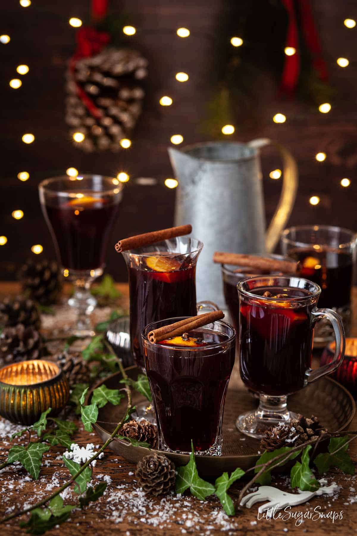 Glasses of vin brulé topped with cinnamon sticks and orange slices