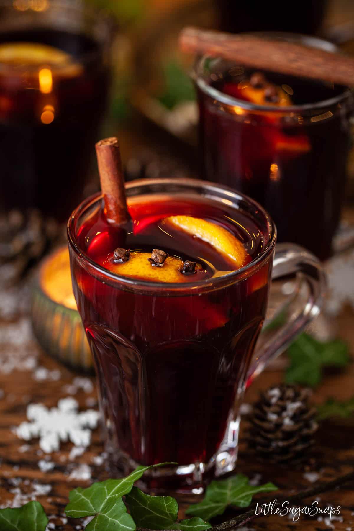 A glass of mulled wine with cinnamon, orange slices and cloves