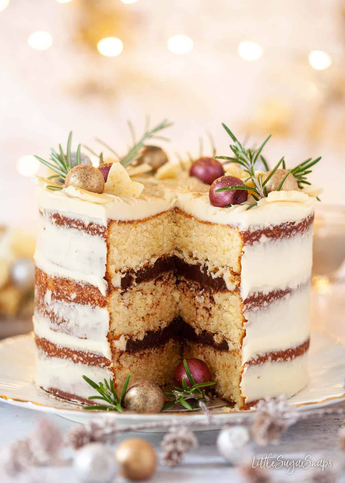 A festive white chocolate cake with a slice cut out of it