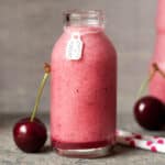 cherry smoothie with coconut in a glass bottle