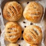 Four Eccles cakes on waxed paper