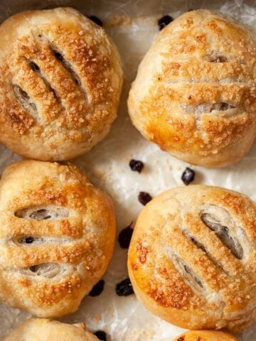 Four Eccles cakes on waxed paper