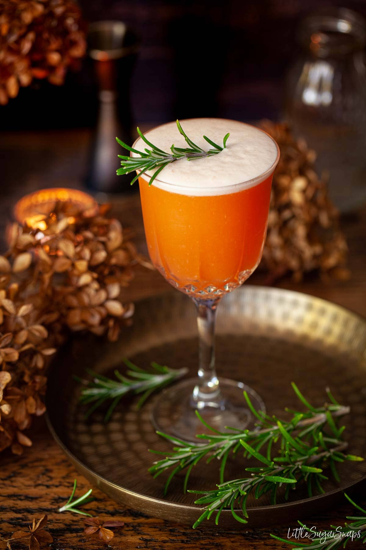 Aperol sour cocktail with egg foam and rosemary garnish