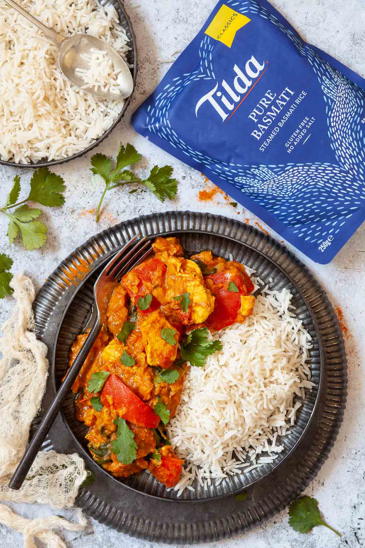 chicken and lentil curry with rice on a plate and a packet of rice alongside