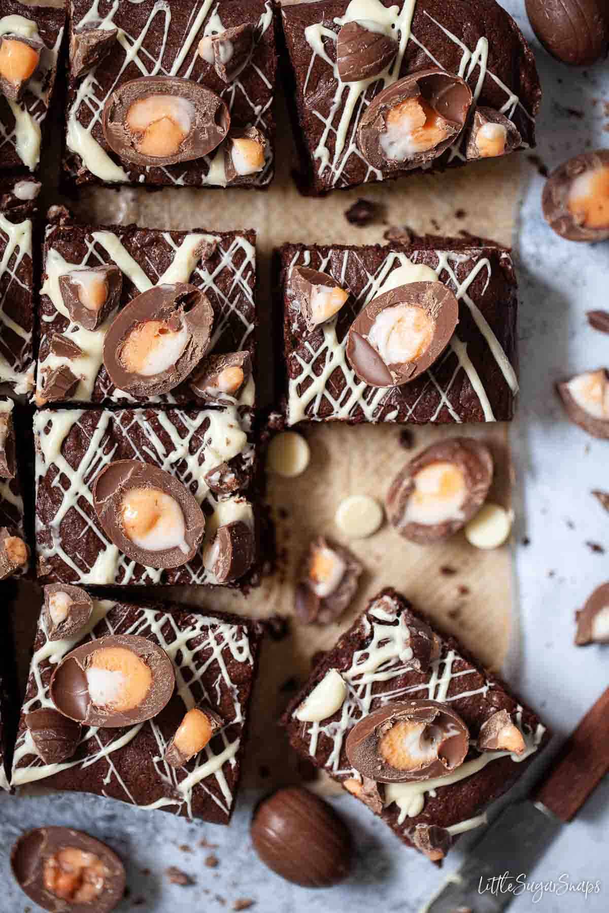 Freshly cut squares of creme egg brownies on parchment paper