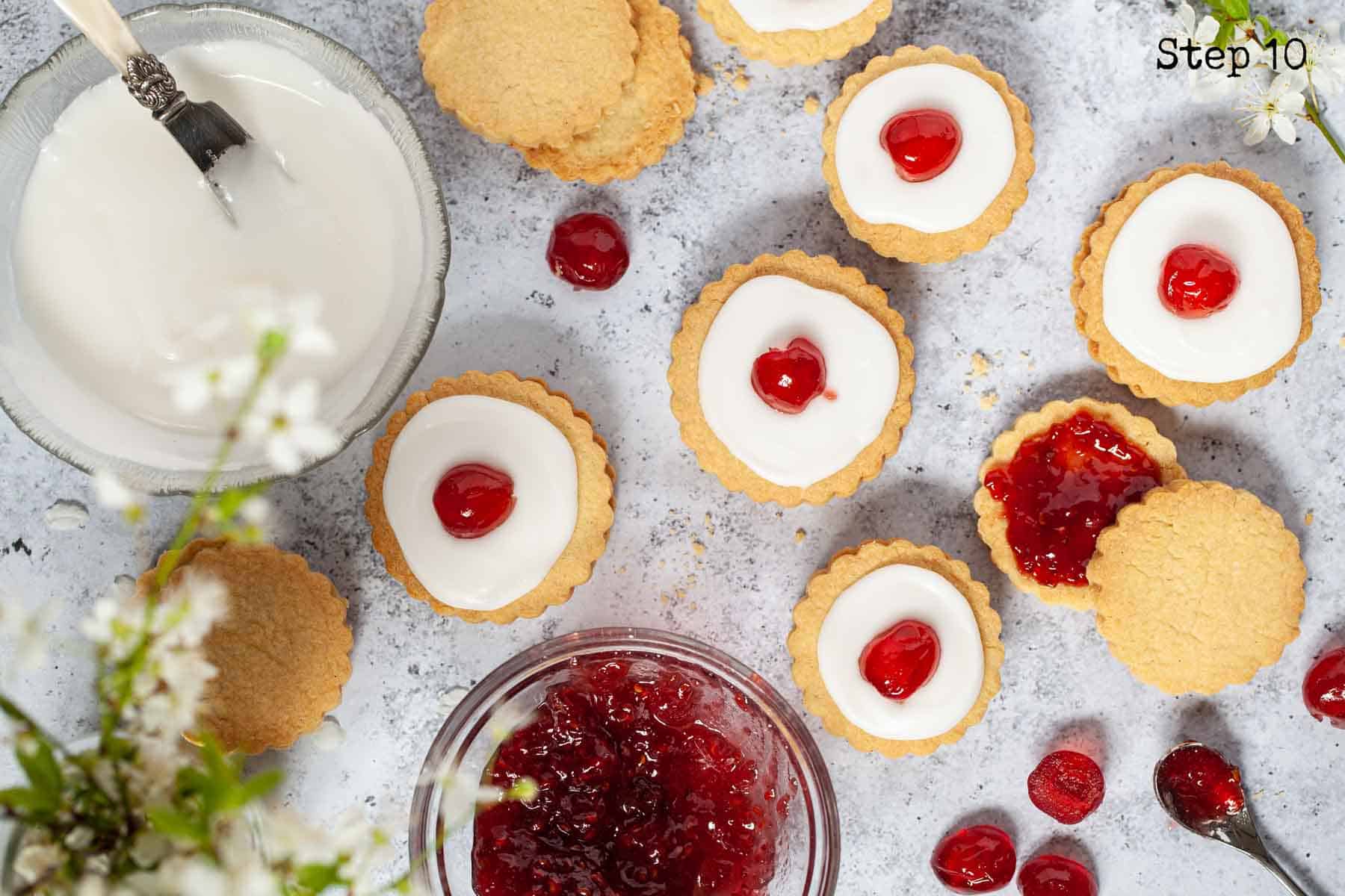 shortbread biscuits being filled with jam and decorated to make imperial cookies