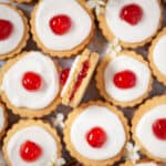 Empire biscuits close up with one on its side with a bite taken out showing the jammy centre