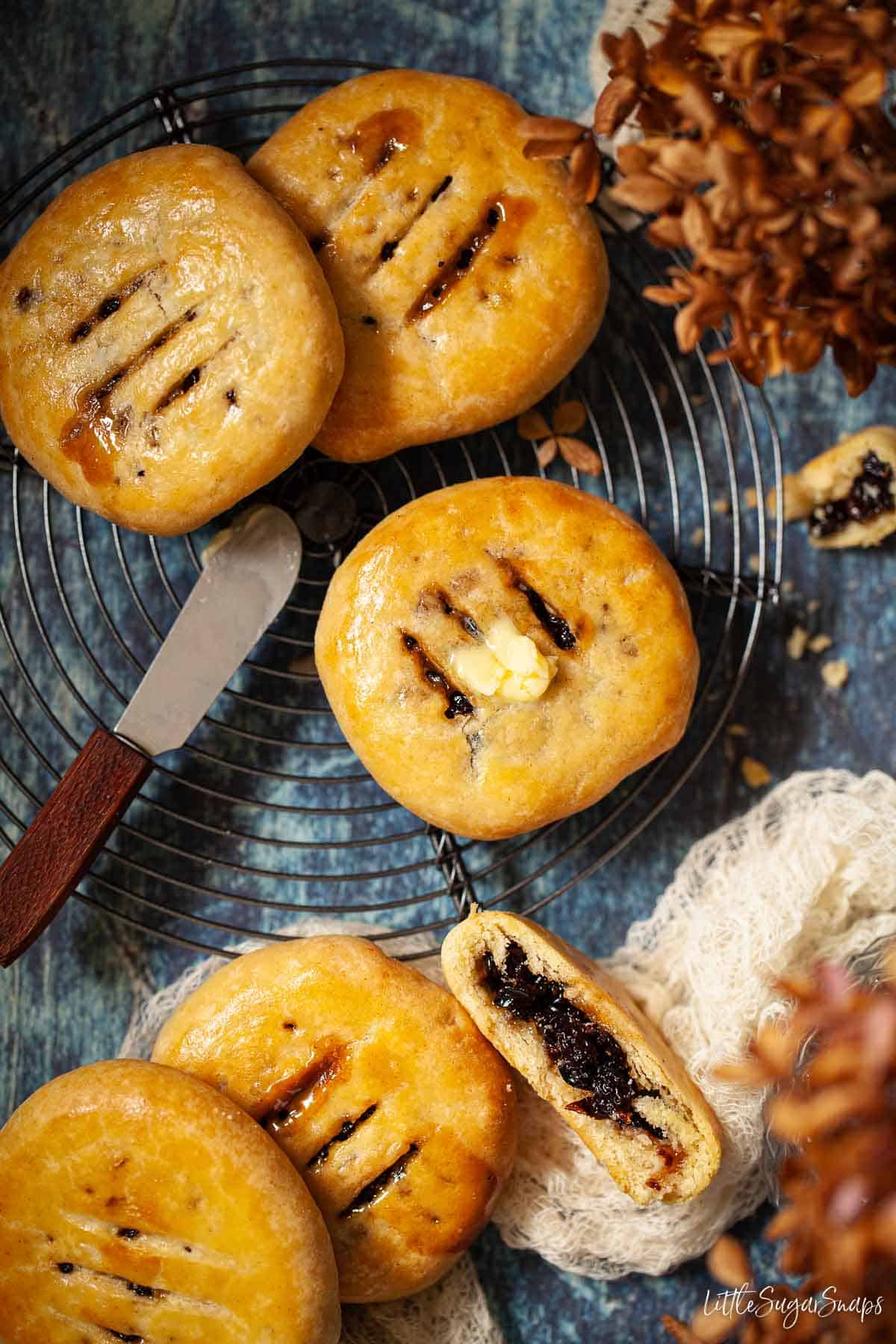 Chorley Cakes on a wire rack - one has butter on top and one is cut open