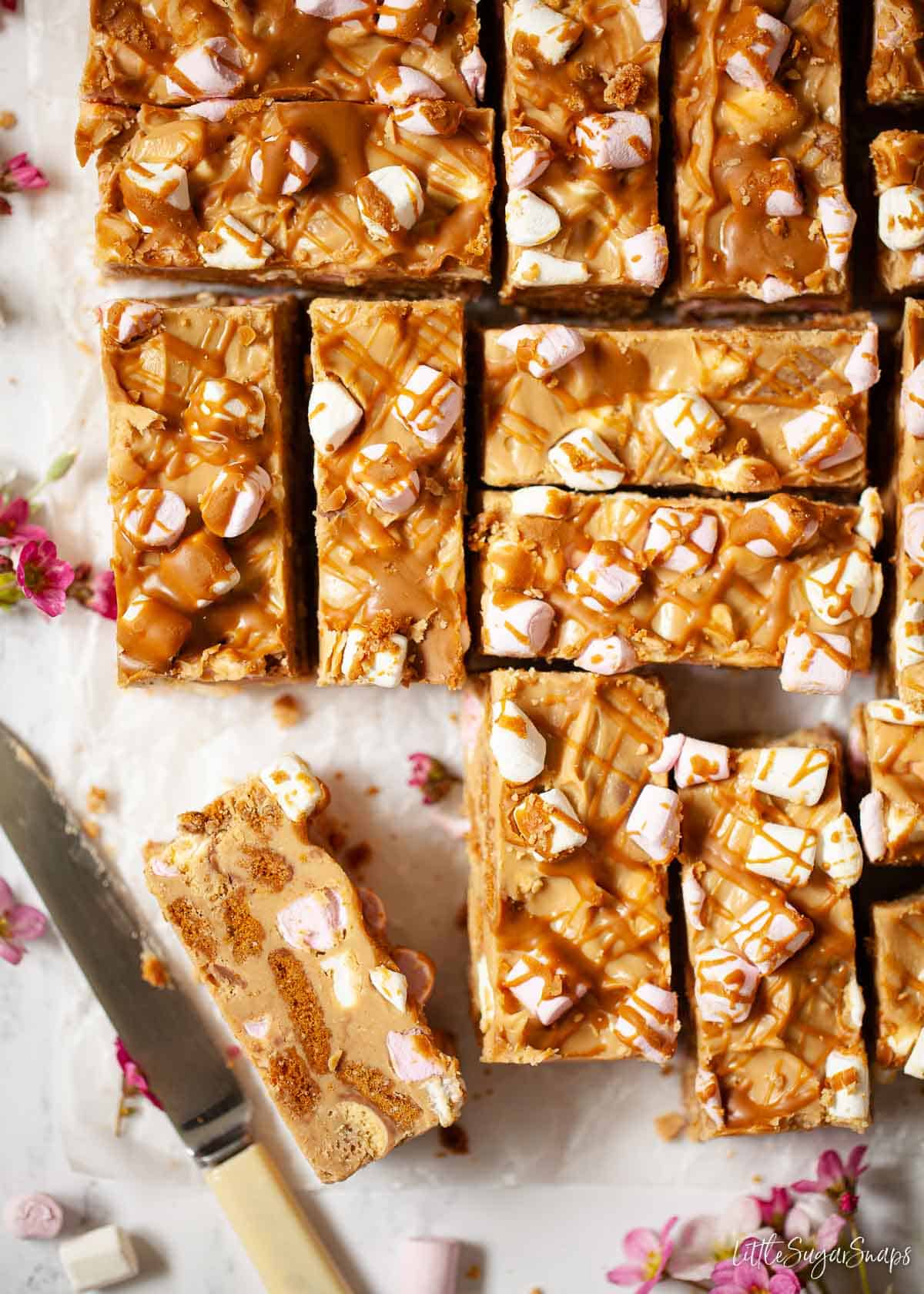 Freshly cut slices of white chocolate and Lotus biscoff rocky road on wax paper