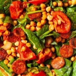 Close up of a roasted chickpea salad with spinach, tomato and chorizo