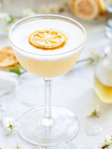 A gin sour with bergamot and camomile. Garnished with egg white foam and dehydrated lemon