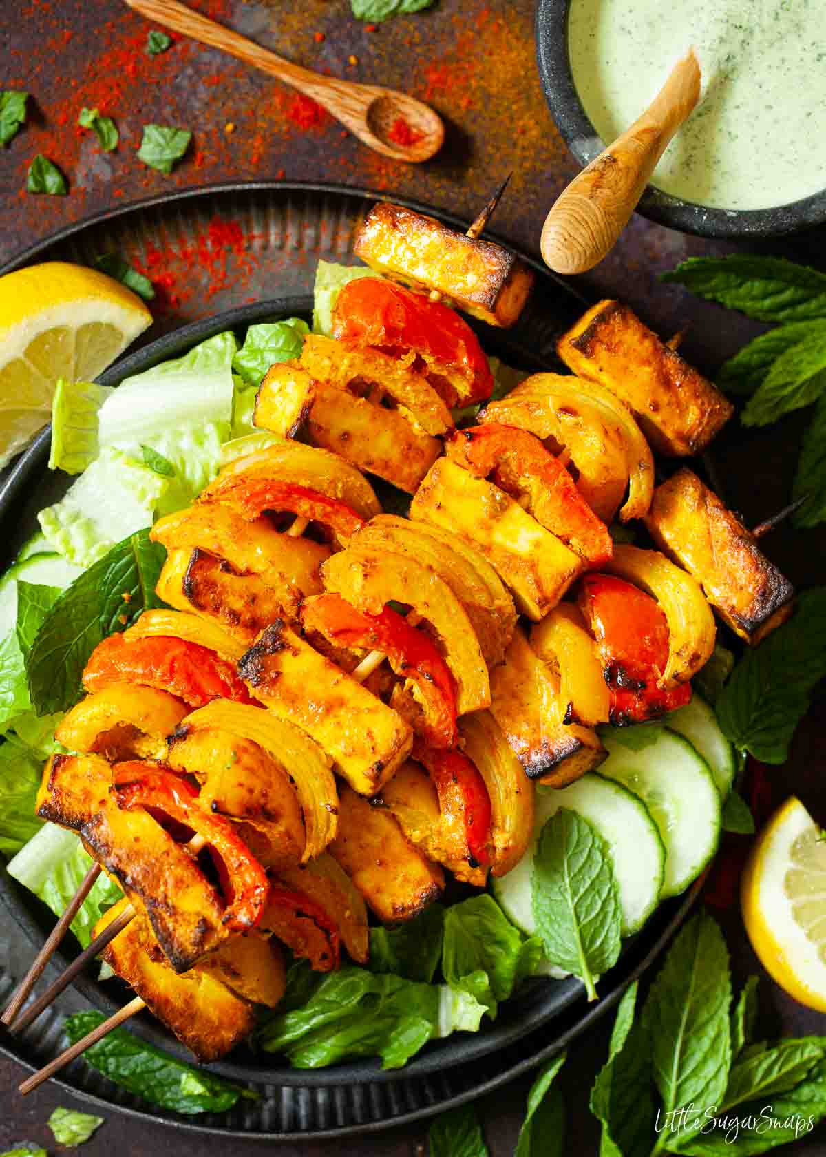 Paneer tikka on skewers with red and yellow peppers