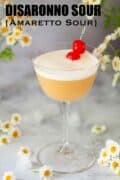 An Amaretto sour cocktail garnished with egg white foam and cocktail cherries with text overlay