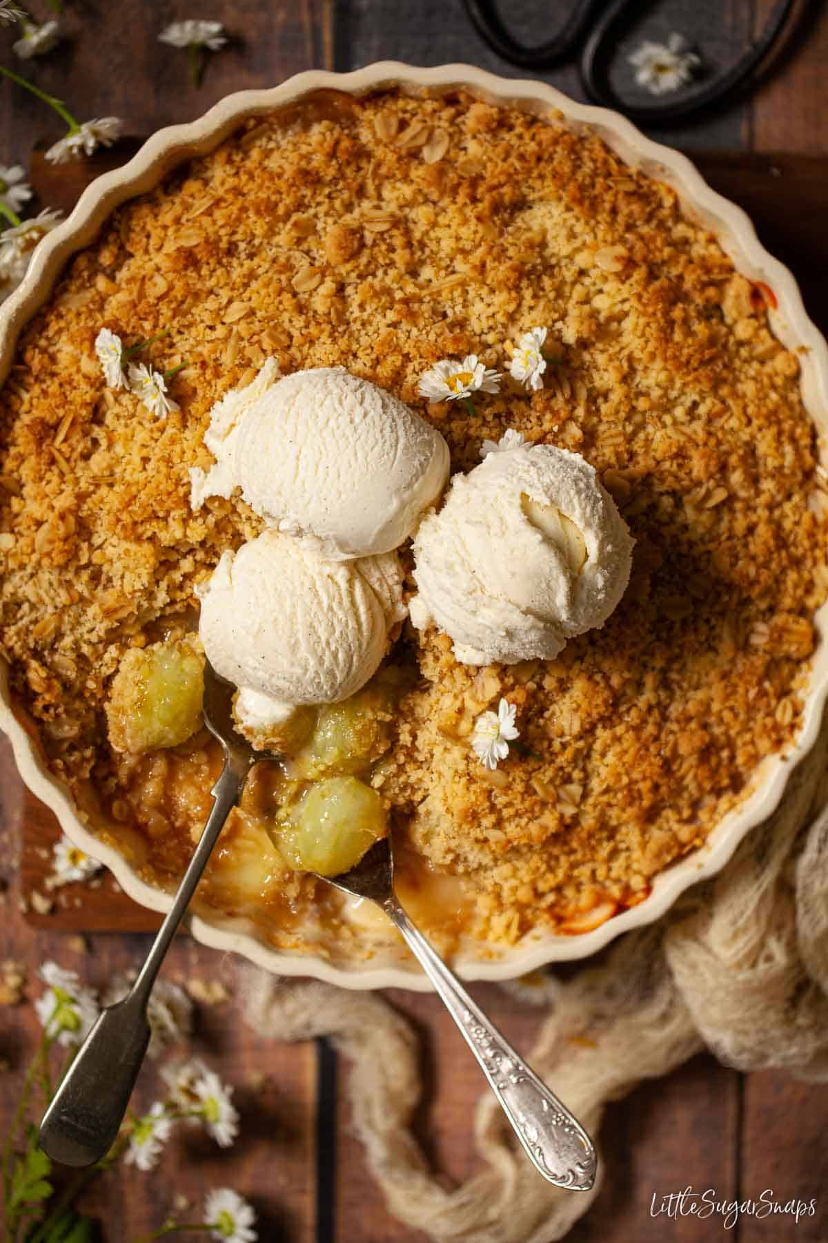 A gooseberry crumble with 3 balls of ice cream on top