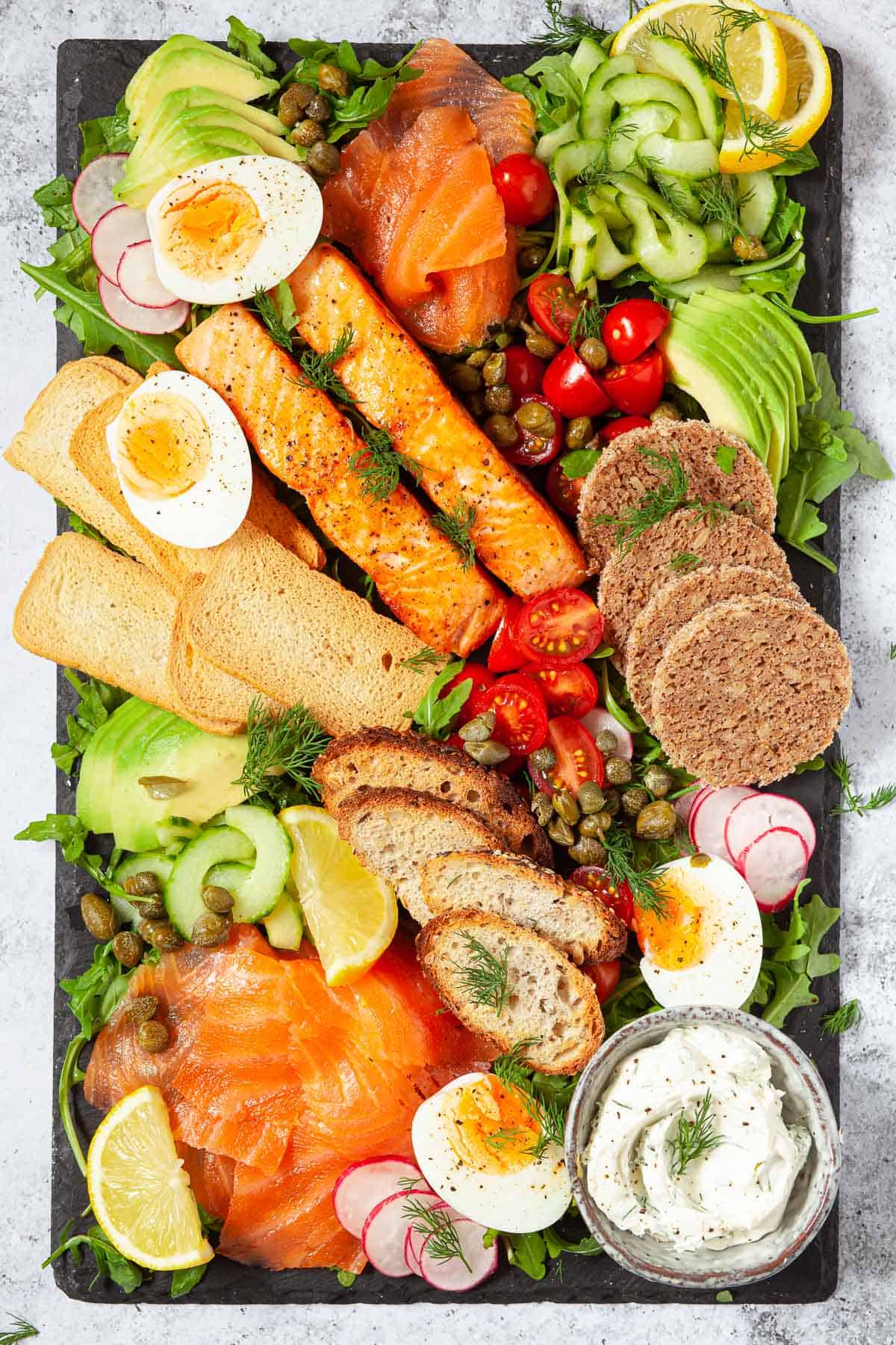 A salmon platter with eggs, vegetables and mixed toasts