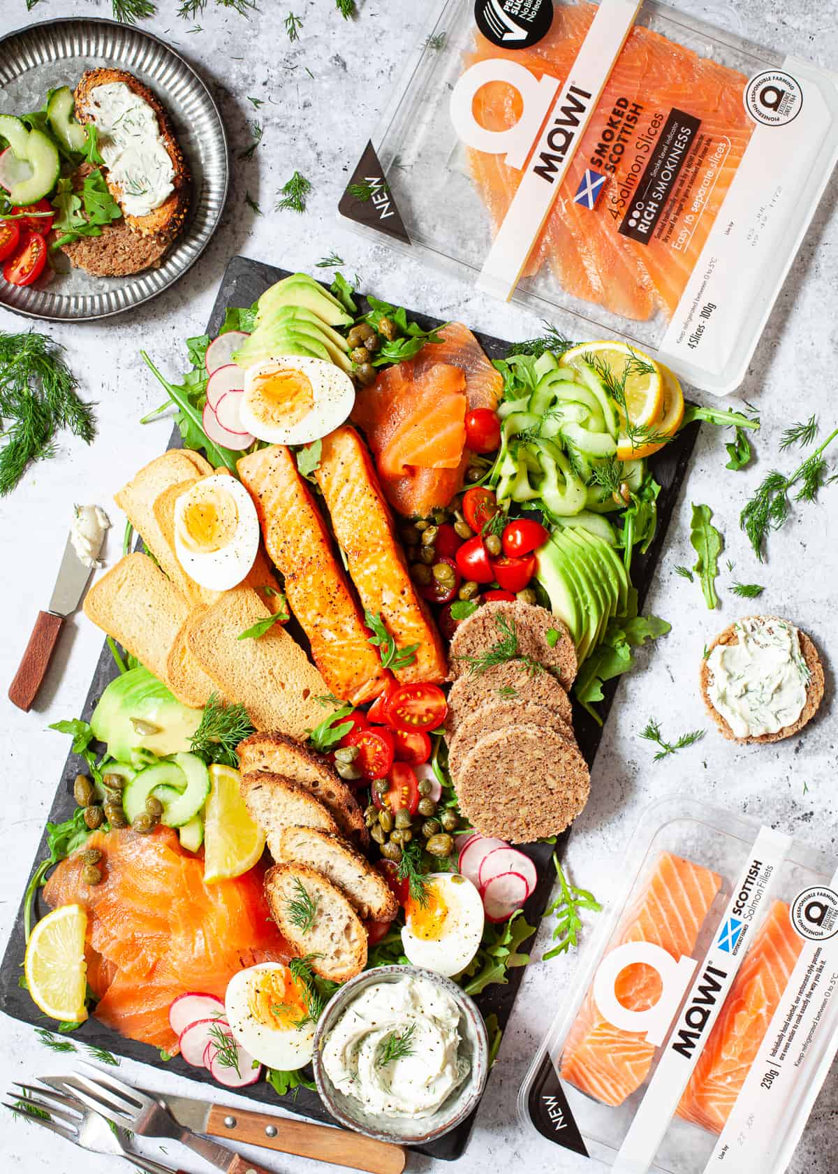 A platter of fresh vegetables, eggs, fish and various breads and toasts