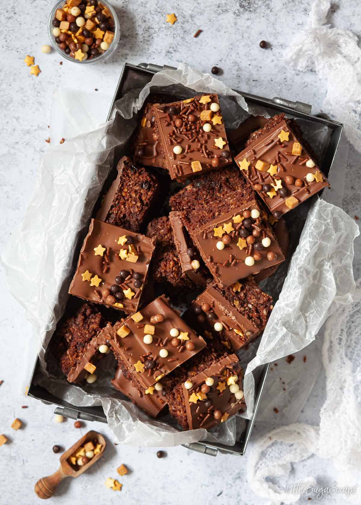 A tin of Australian Crunchie bars topped with chocolate and sprinkles