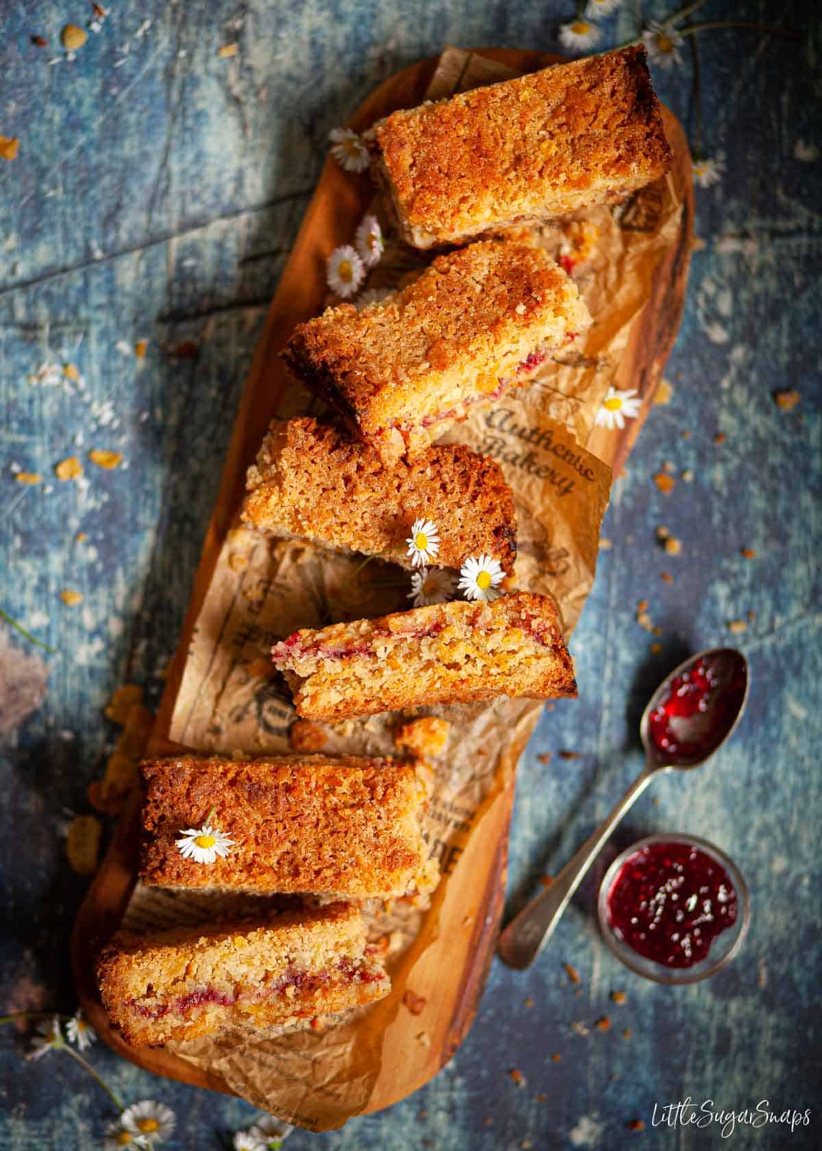 Ccoconut and cereal bars with a jam centre on a wooden platter