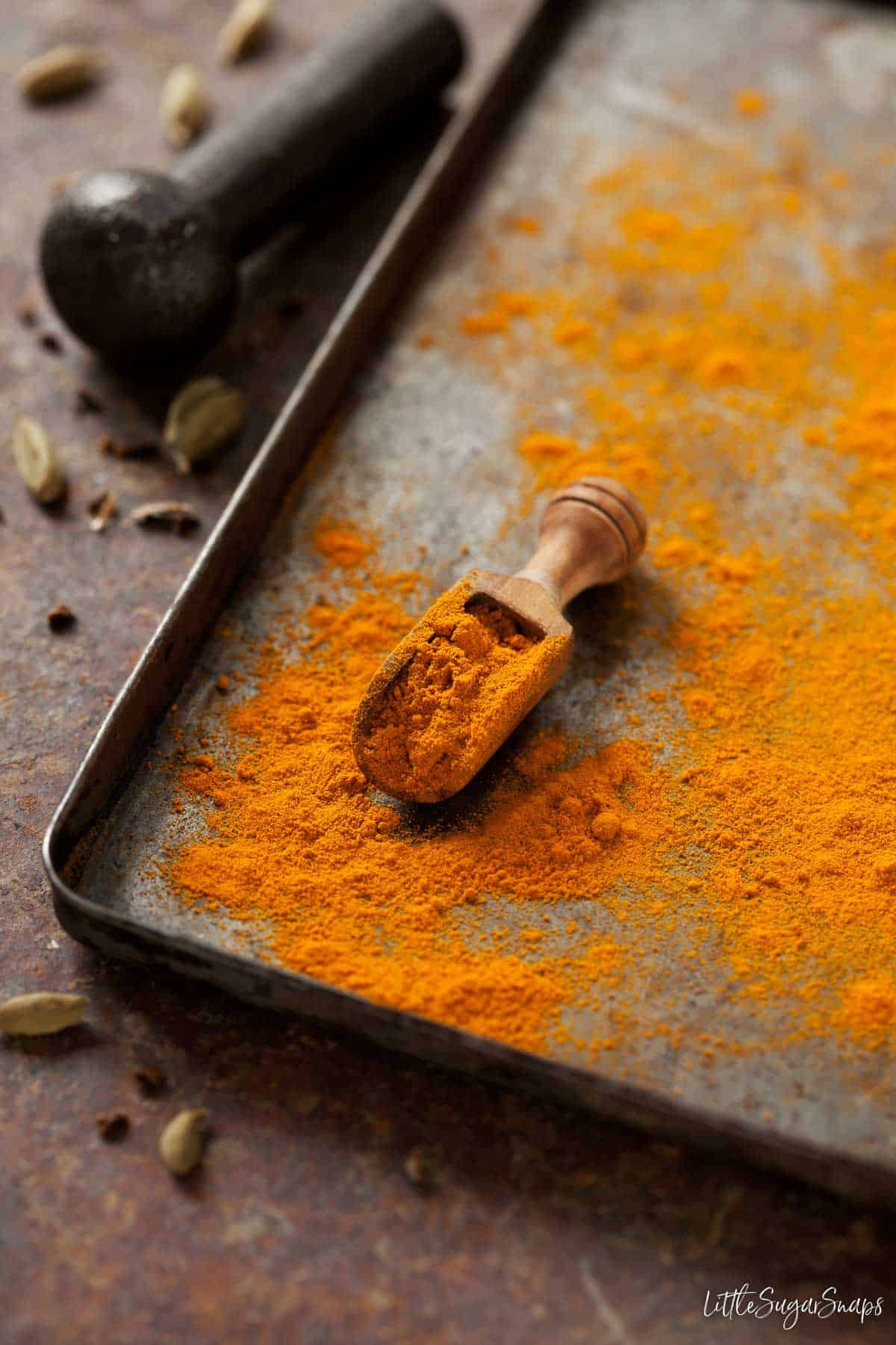 Ground turmeric spice on a baking tin