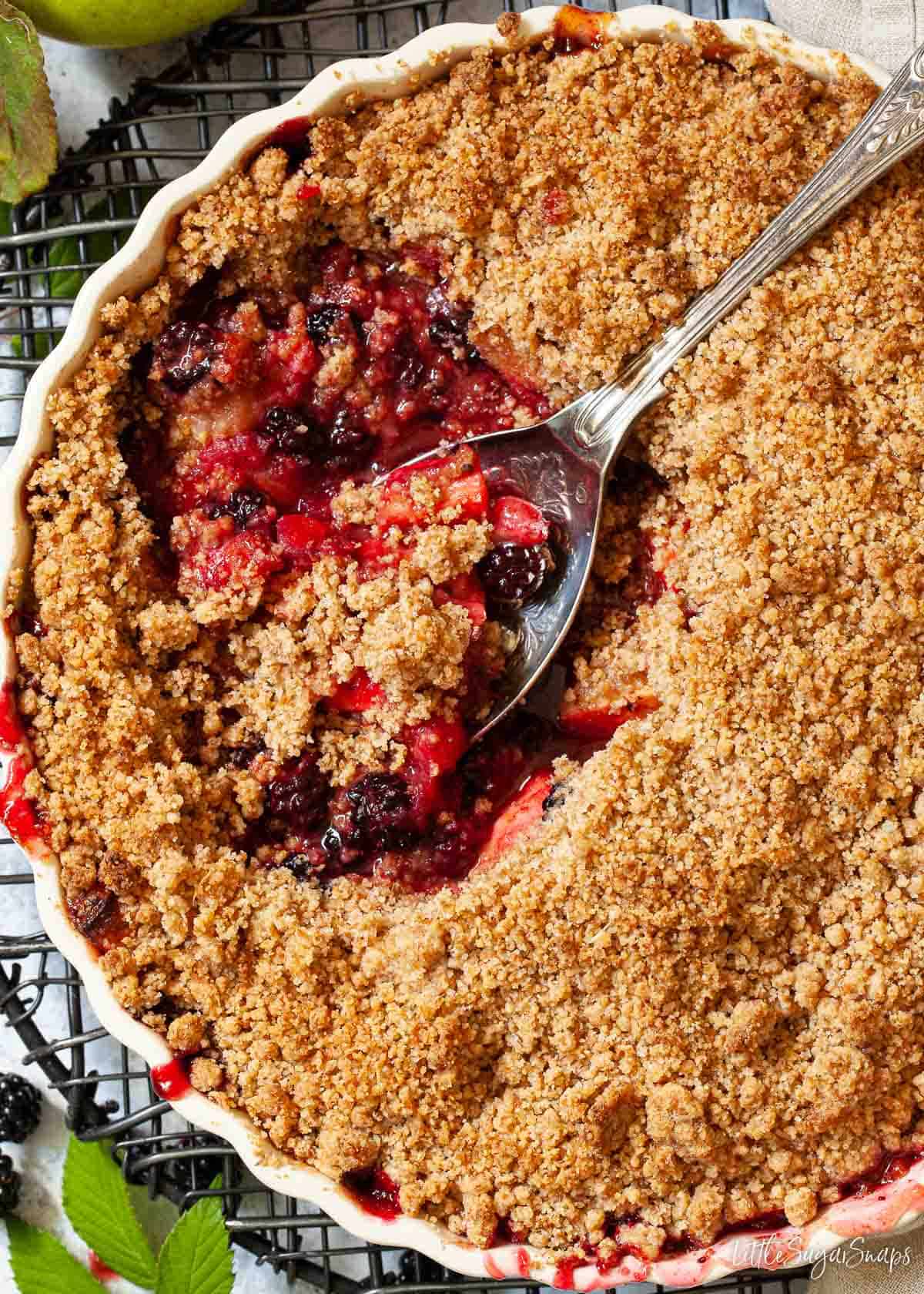 Close up of a part served apple and blackberry crumble